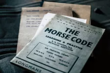 Gamla dokument ligger i en hög. Översta dokumentet har rubriken "The morse code". Foto.